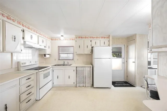 a view of an empty room with furniture and a window