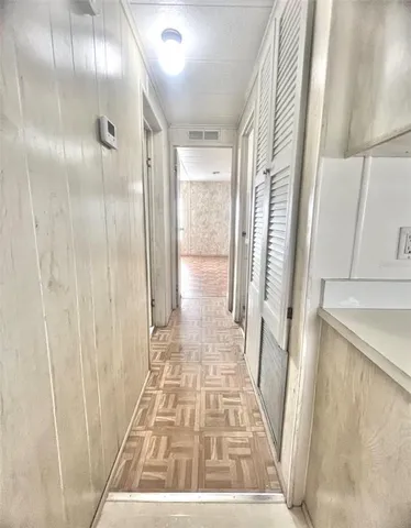 a view of an empty room and chandelier fan