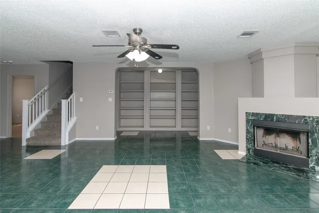 a view of an empty room with a fireplace and window