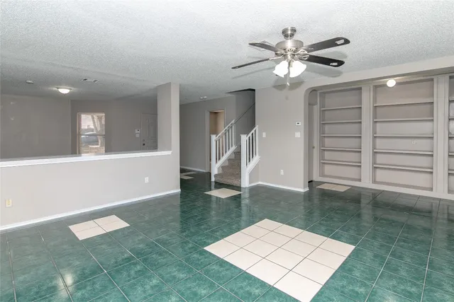 a view of a livingroom with a ceiling fan and hardwood floor