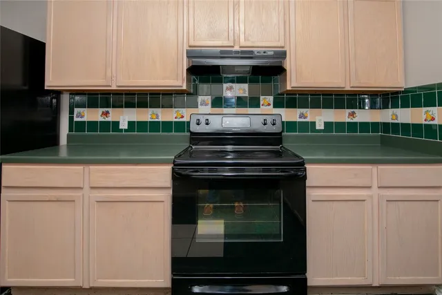 a kitchen with a stove and white cabinets