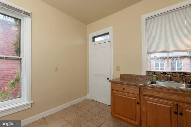 a bathroom with a granite countertop sink and a window
