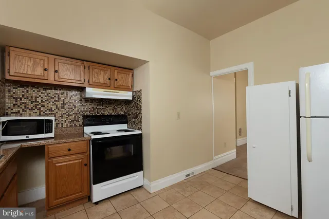 a kitchen with a stove top oven and refrigerator