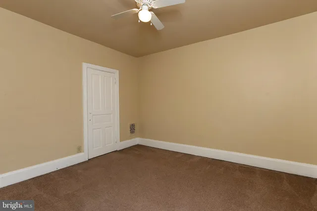 an empty room with a chandelier fan