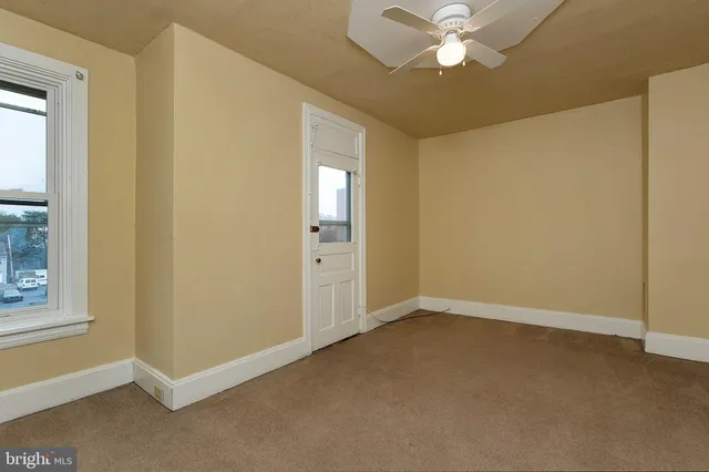 an empty room with closet and a chandelier fan