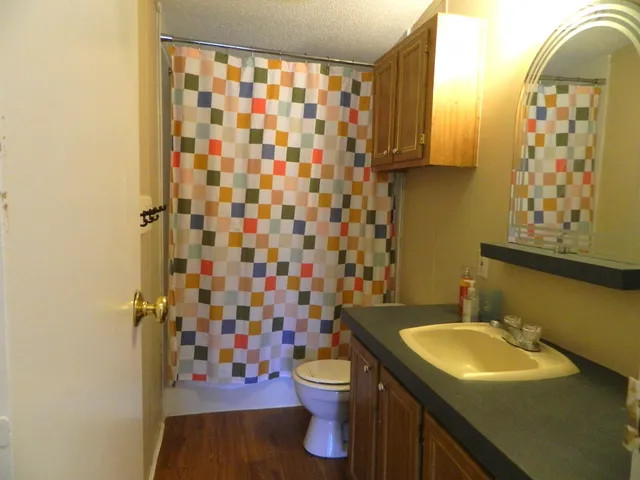 an empty room with a window and chandelier fan
