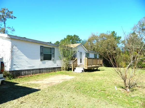 a view of deck with wooden floor and fence next to a yard