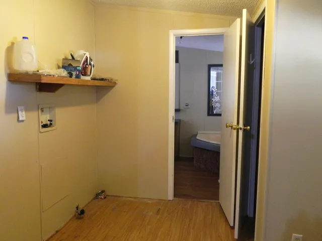 an empty room with a window and a fan