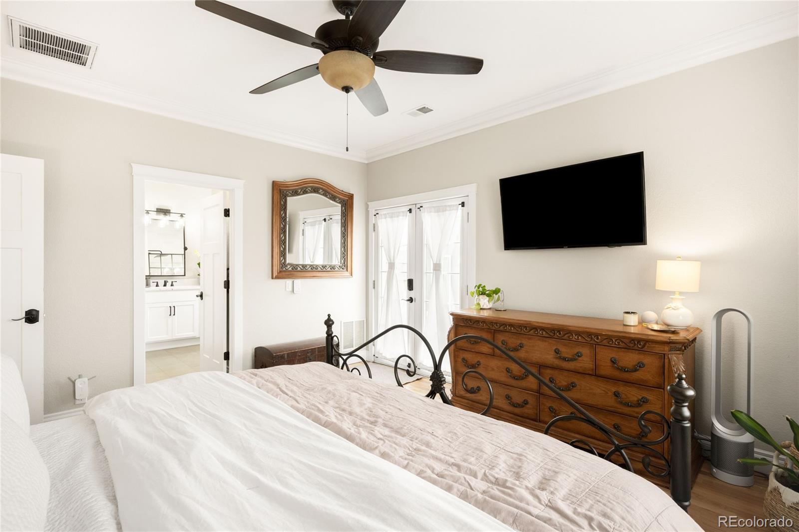 3017 Steele Street Denver, CO 80205 - Photo 12 of 36 a bedroom with a bed and a flat screen tv