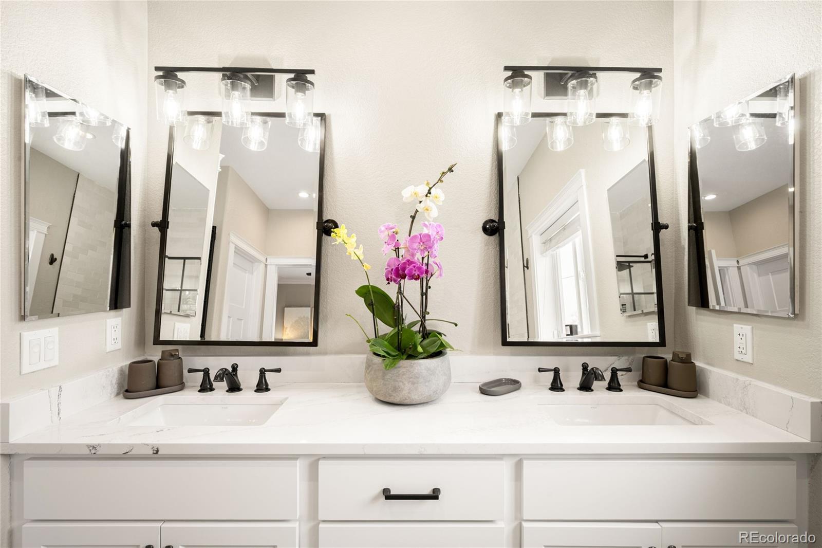 3017 Steele Street Denver, CO 80205 - Photo 13 of 36 a bathroom with a sink a mirror and a shower