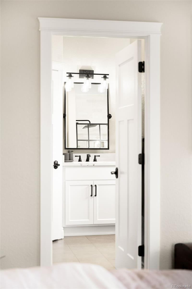 3017 Steele Street Denver, CO 80205 - Photo 15 of 36 a bathroom with a sink a mirror and shower