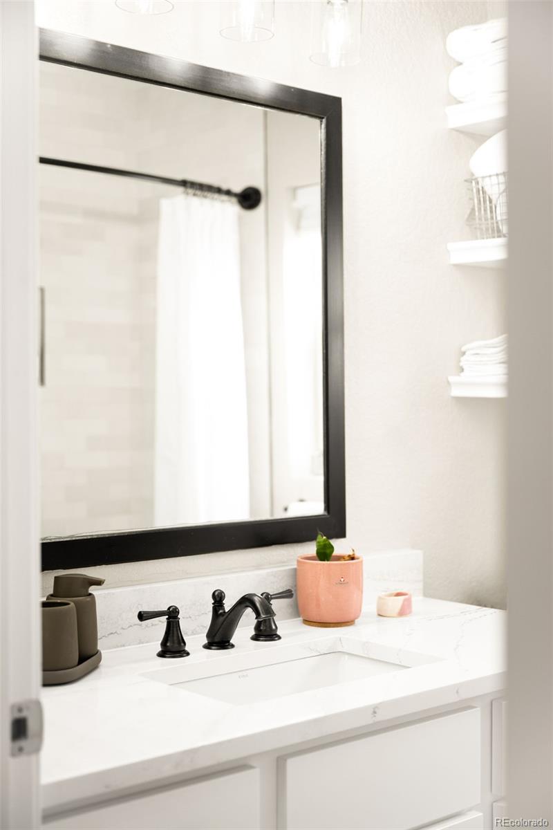 3017 Steele Street Denver, CO 80205 - Photo 21 of 36 a bathroom with a sink and a mirror