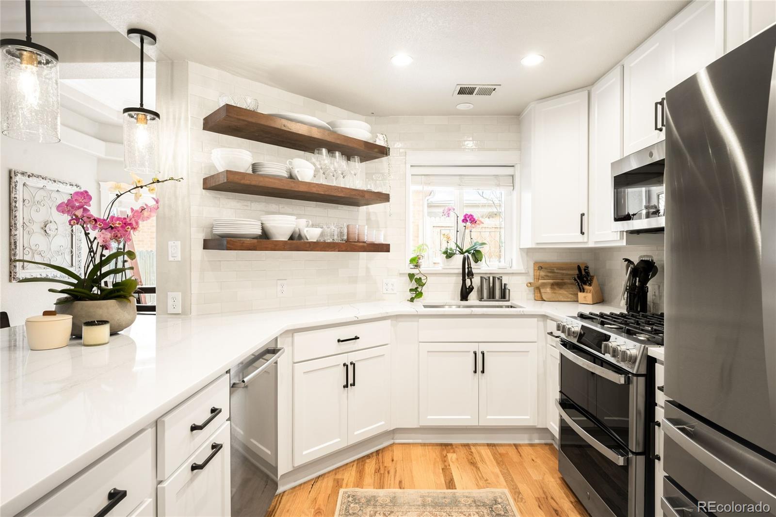 3017 Steele Street Denver, CO 80205 - Photo 7 of 36 a kitchen with stainless steel appliances a sink a stove and cabinets
