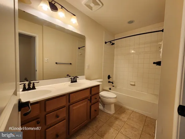 a bathroom with a double vanity sink toilet mirror and shower