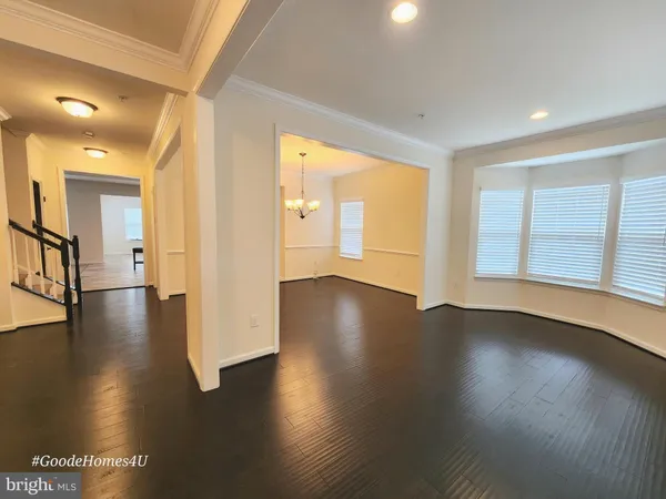 a view of a big room with wooden floor and windows