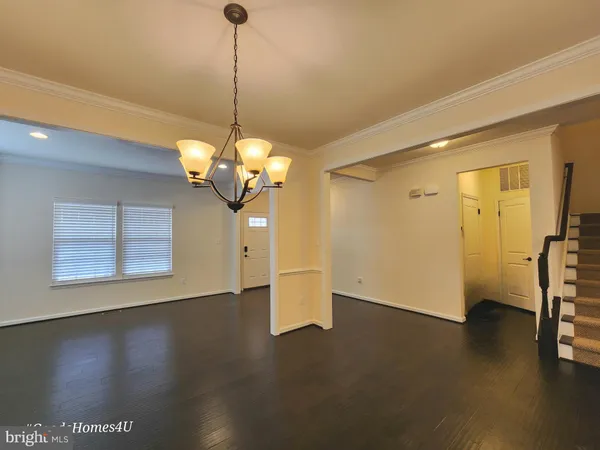 a view of a room with wooden floor and a ceiling fan