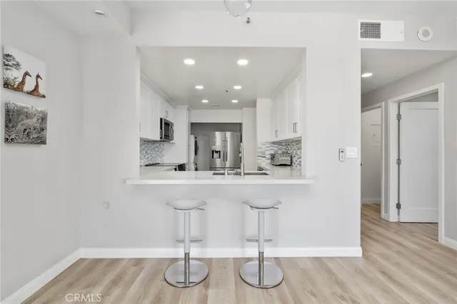 a kitchen with stainless steel appliances granite countertop a sink cabinets and wooden floor