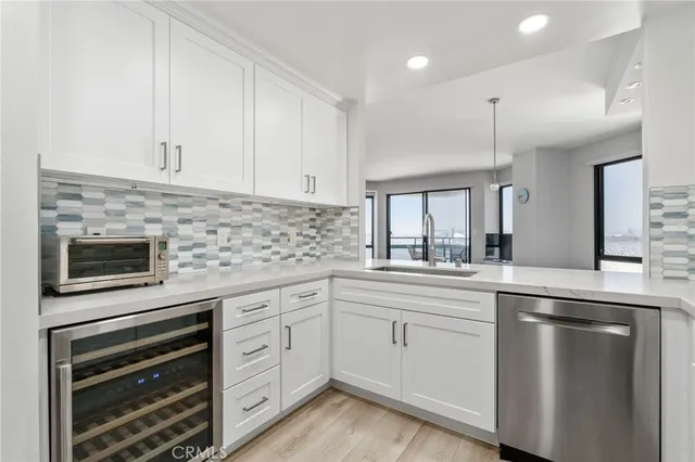 a kitchen with white cabinets and appliances