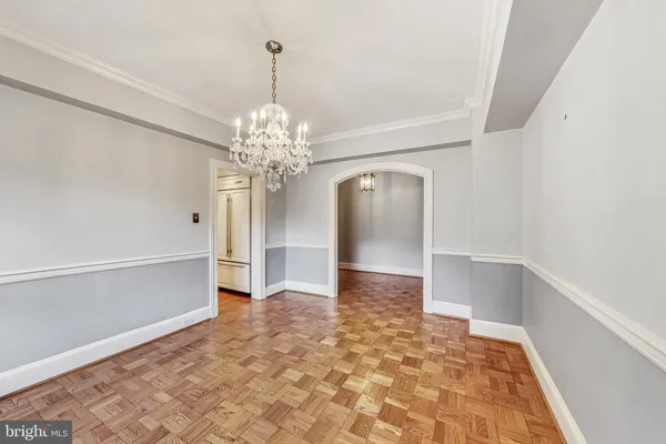 a view of a livingroom with a chandelier fan and kitchen view