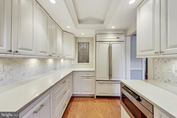 a kitchen with white cabinets and white appliances