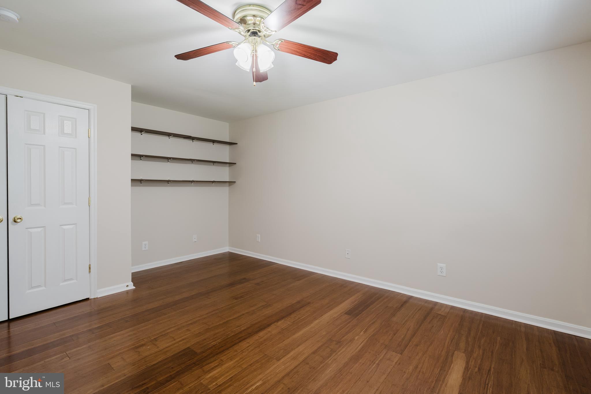 33 Hummingbird Lane Newark, DE 19711 - Photo 40 of 61 an empty room with wooden floor chandelier fan and windows