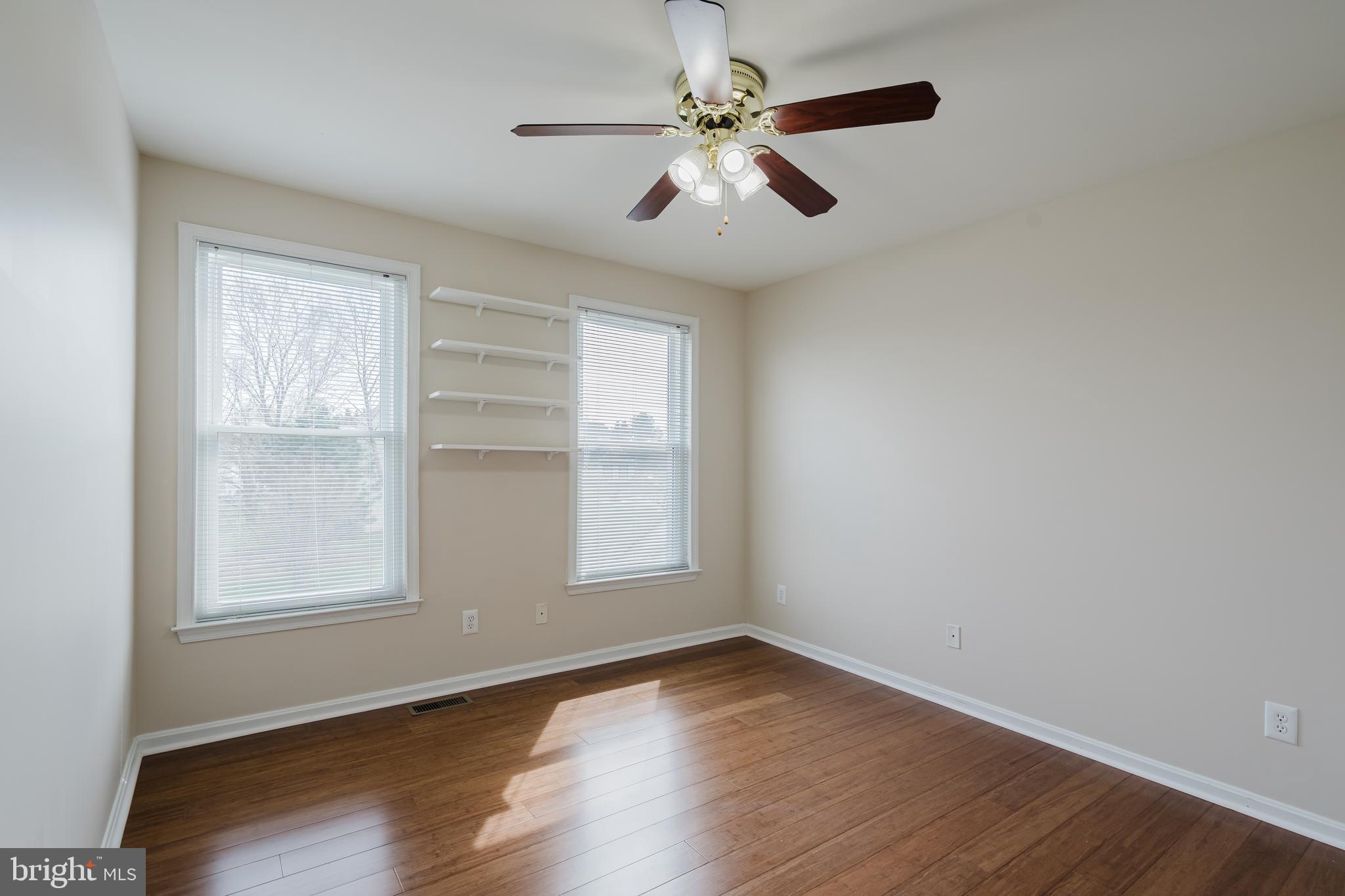 33 Hummingbird Lane Newark, DE 19711 - Photo 41 of 61 an empty room with wooden floor chandelier fan and windows