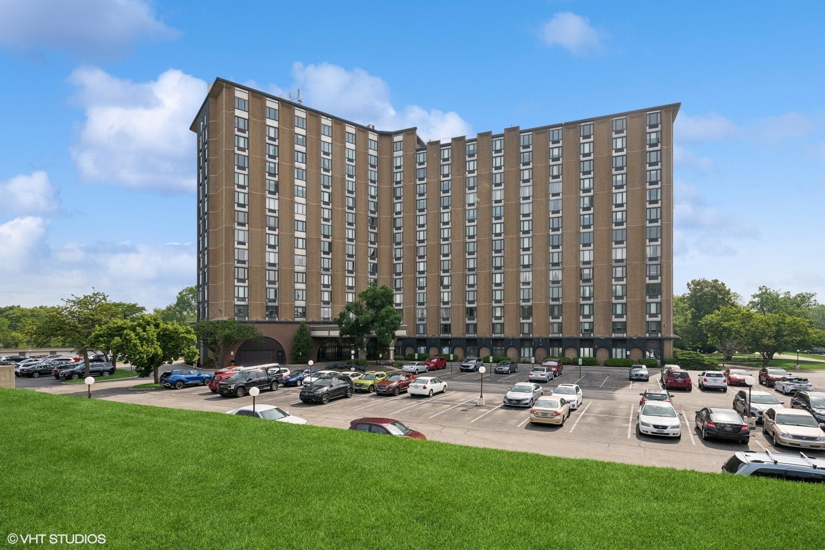 a front view of a building with outdoor seating and green space