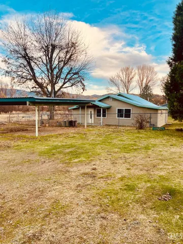 a backyard of a house with table and chairs