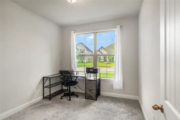 a view of a workspace with furniture and a window