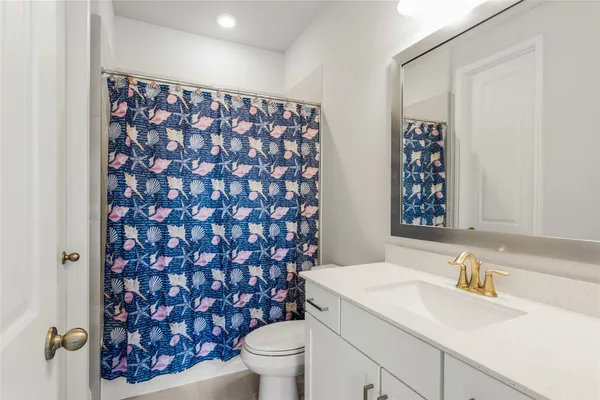 a bathroom with a granite countertop toilet sink and mirror