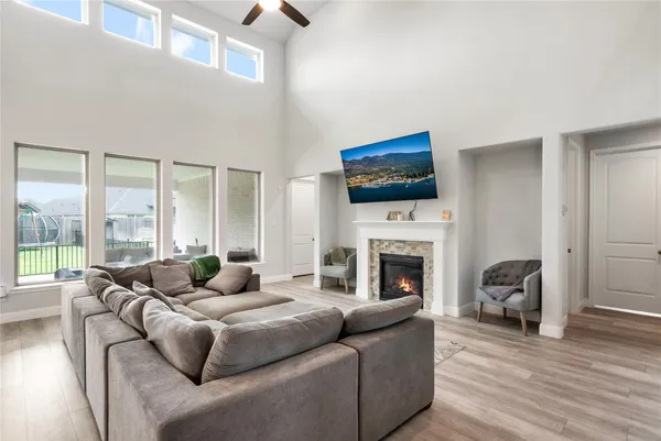 a living room with furniture a fireplace and a floor to ceiling window