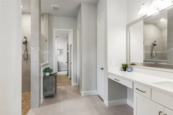 a spacious bathroom with a shower sink and mirror