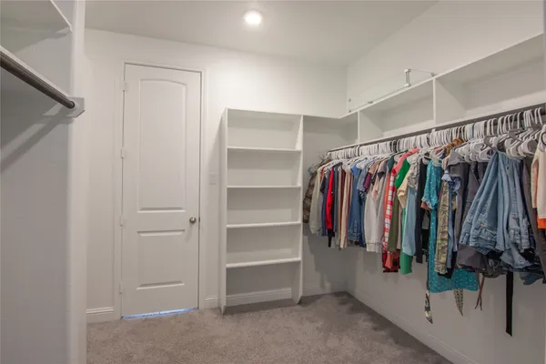 a view of walk in closet with clothes