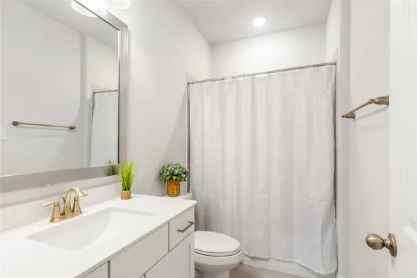 a bathroom with a sink a toilet and shower curtain