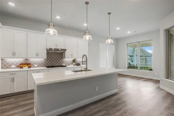 a kitchen with counter top space and wooden floor