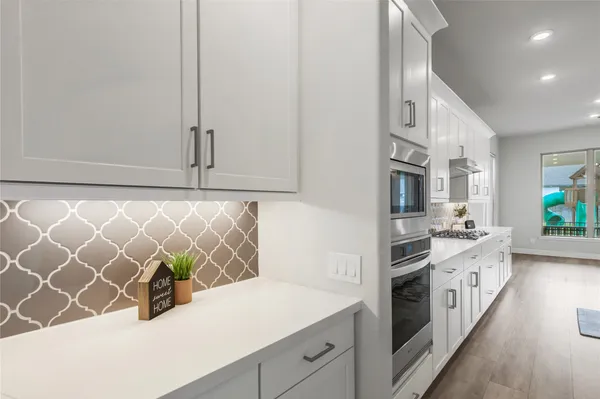 a kitchen with granite countertop white cabinets and white appliances