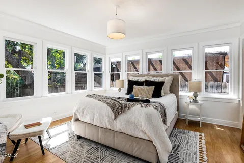 a bedroom with a bed and wooden floor