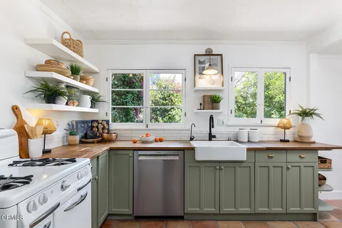 a kitchen with a sink stove top oven and cabinets