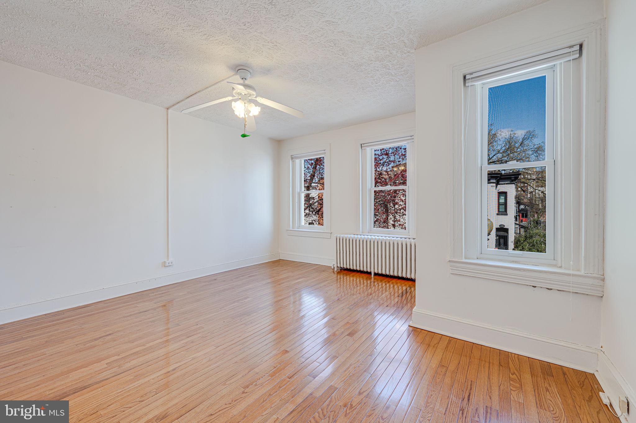 1502 Caroline Street Northwest Washington, DC 20009 - Photo 11 of 22 a view of an empty room with wooden floor and a window