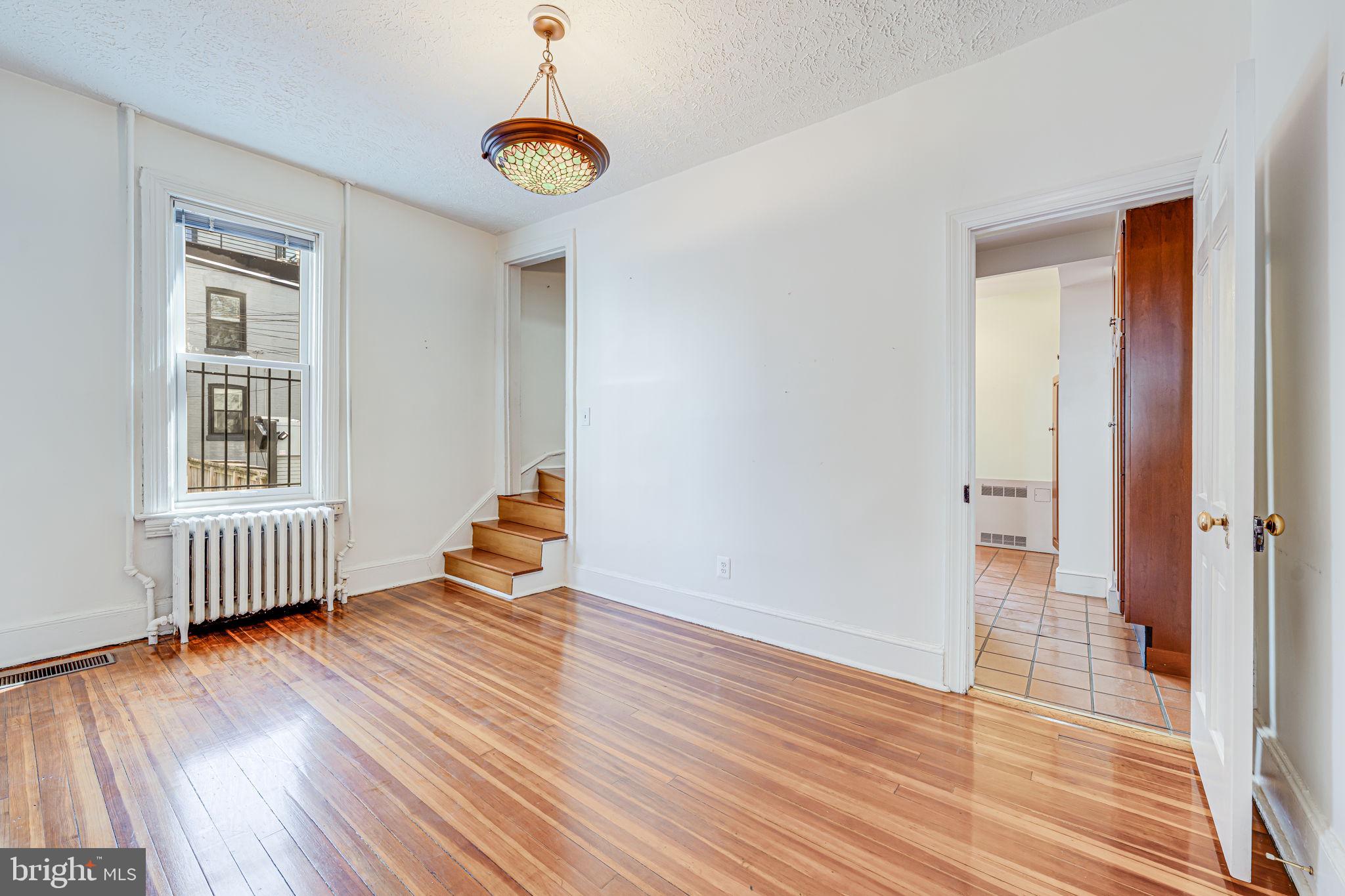 1502 Caroline Street Northwest Washington, DC 20009 - Photo 7 of 22 wooden floor in an empty room with a window