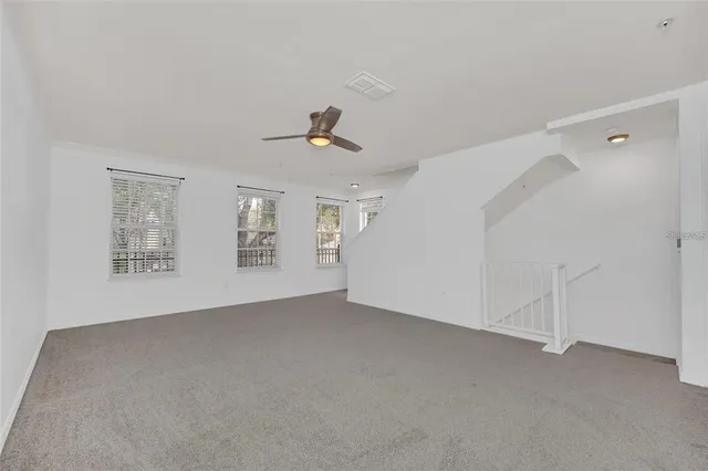 a view of a big room with chandelier fan and windows