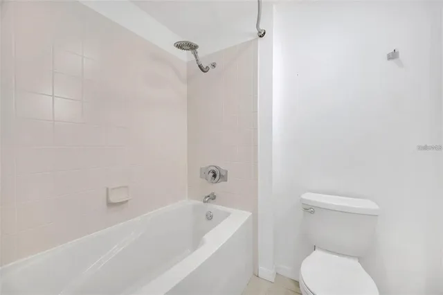 a white toilet sitting next to a bath tub