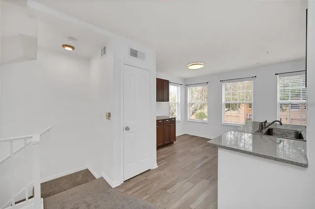a kitchen with stainless steel appliances kitchen island granite countertop a refrigerator and a sink