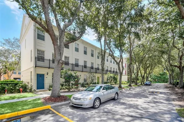 a white house that has a tree in front of it