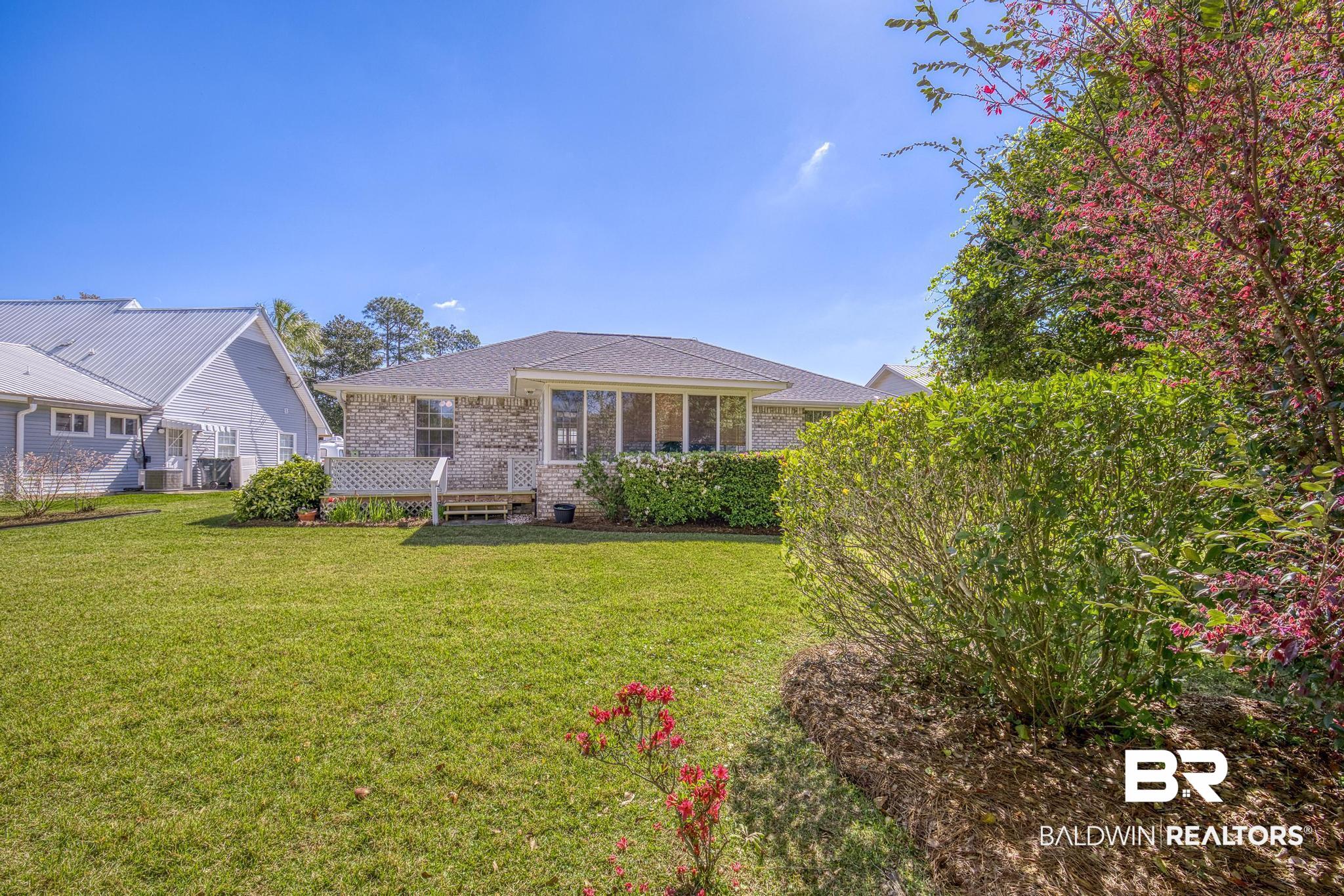 2881 Eslava Circle Lillian, AL 36549 - Photo 29 of 58 Rear view of house featuring a yard and brick siding