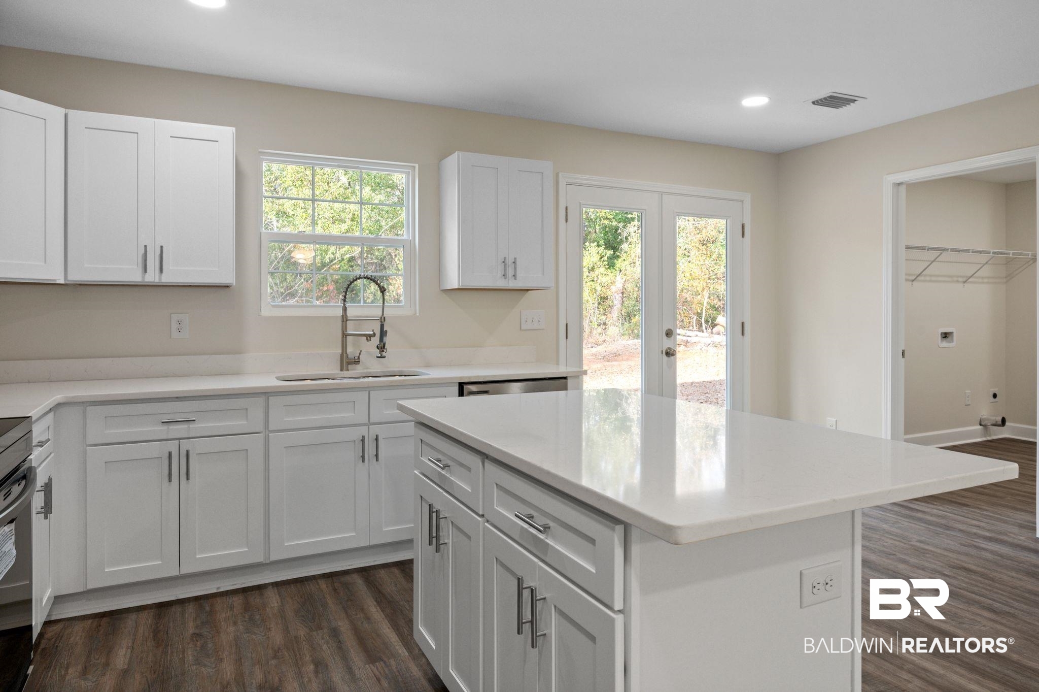 1473 Pollard Road Daphne, AL 36526 - Photo 12 of 32 Kitchen featuring sink, white cabinetry, dark hardwood / wood-style floors, a center island, and stainless steel dishwasher