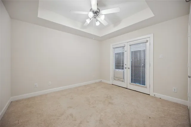 an empty room with chandelier fan and ceiling fan
