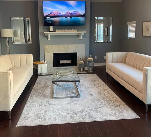 a living room with furniture a flat screen tv and a fireplace