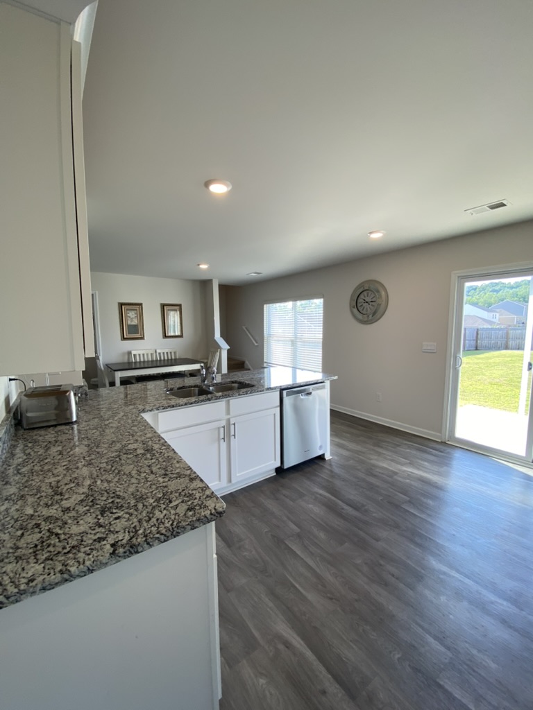 105 Rustic Rdg Drive Easley, SC 29640 - Photo 7 of 23 Granite counters and wood flooring complement this open-concept kitchen with sliding glass doors.