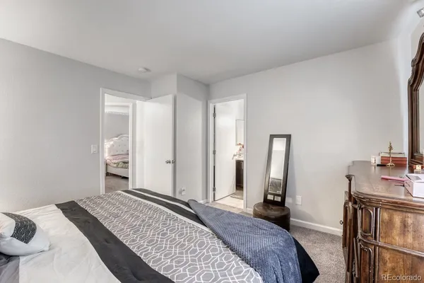 a bedroom with a bed and a large mirror on the dresser
